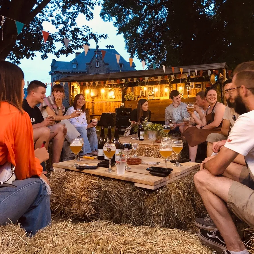Visiteurs installés sur des ballots de paille devant la buvette en bois aux American Days de Vielsalm