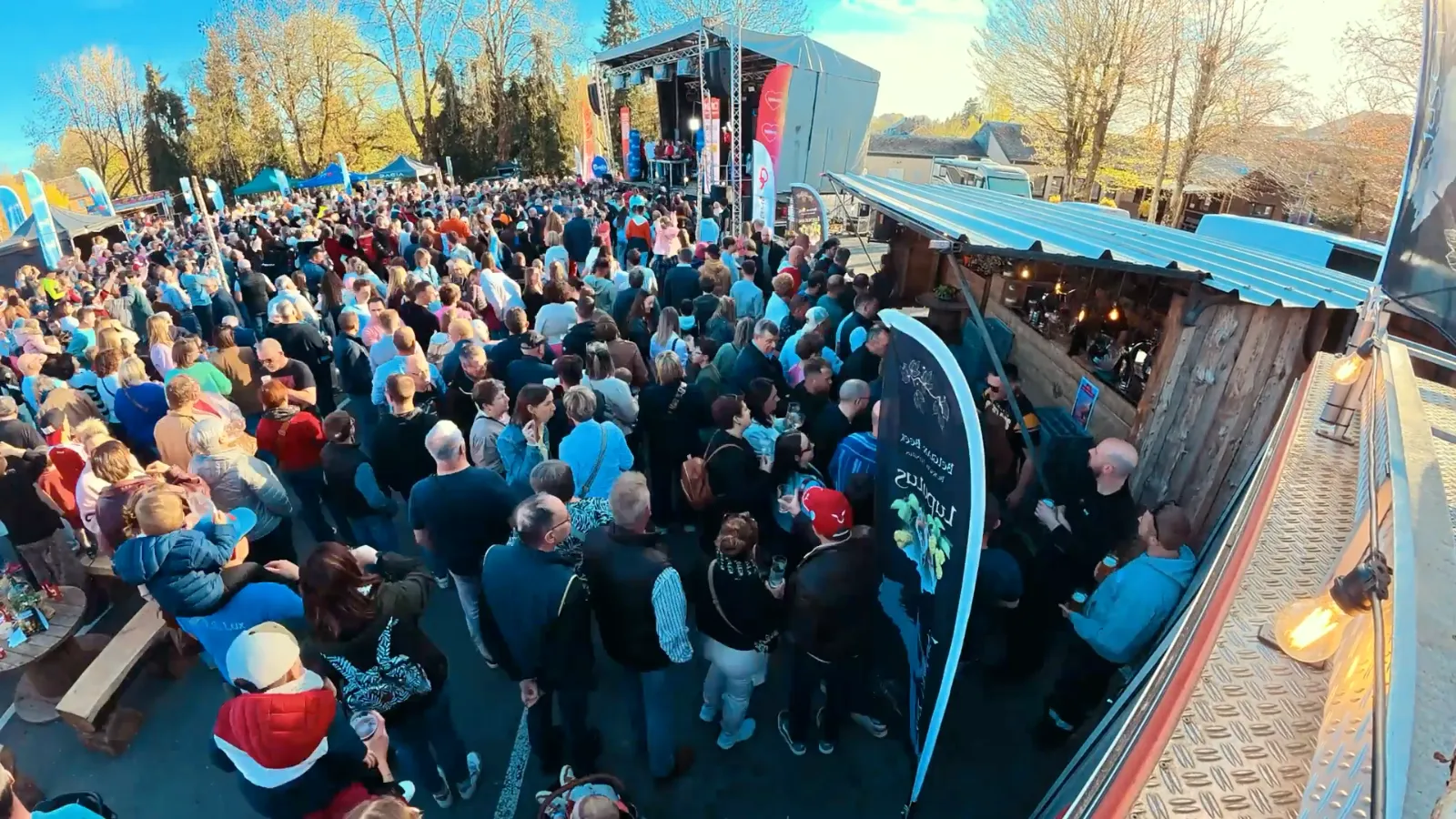 Foule devant la scène et le bar mobile de La Buvette Champêtre au Cuistax du Télévie