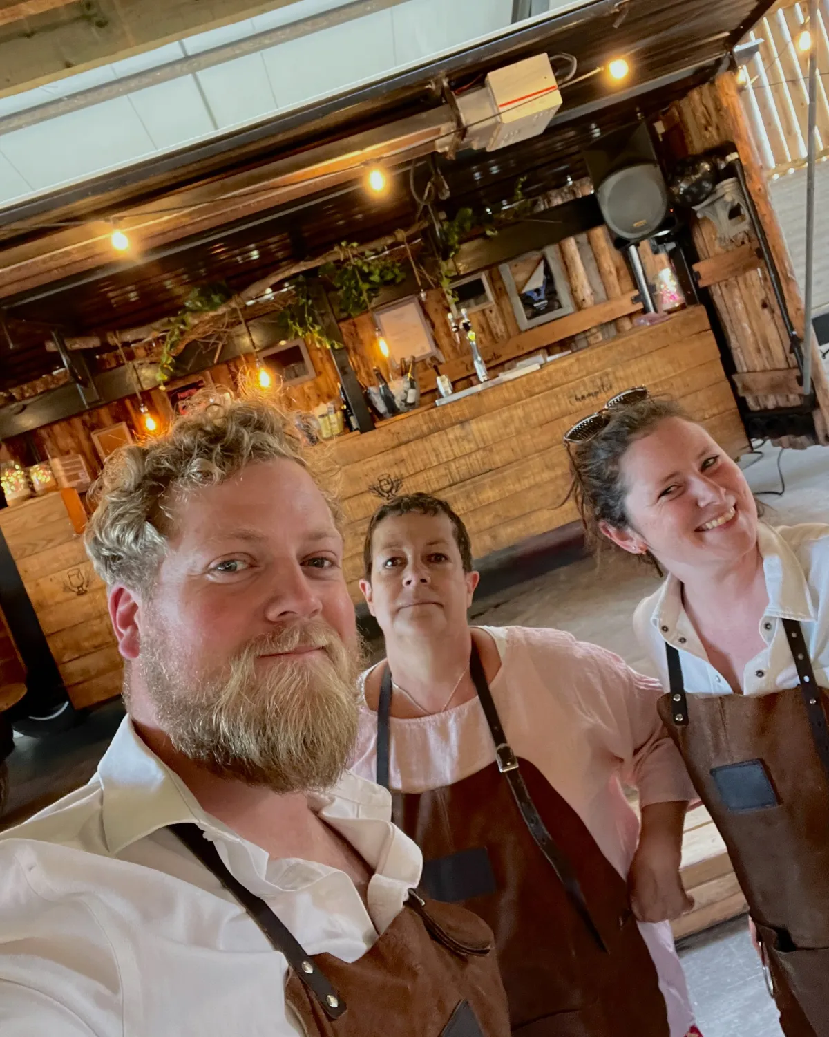 Nicolas, Laure-Anne et Cathy, associés de La Buvette Champêtre, devant leur buvette en bois