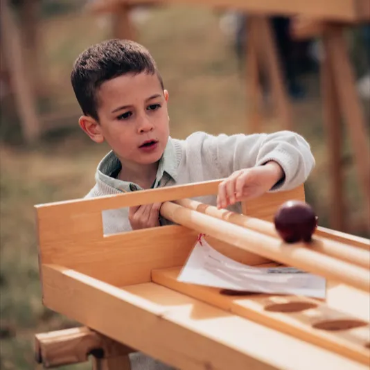 Enfant jouant à un jeu en bois lors d’une réception, animation proposée par un partenaire