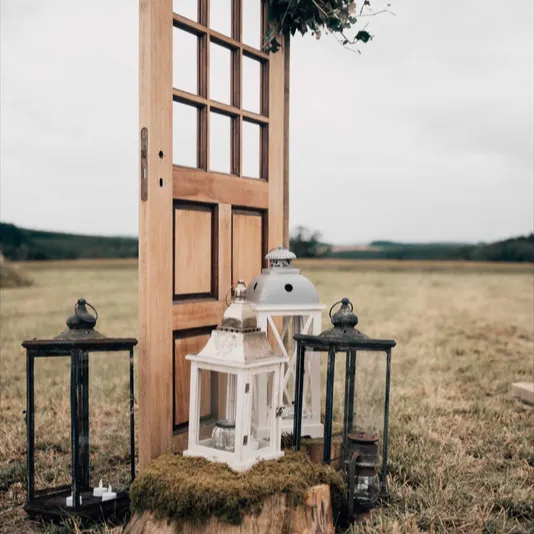 Décor champêtre avec porte ancienne et lanterne dans une prairie
