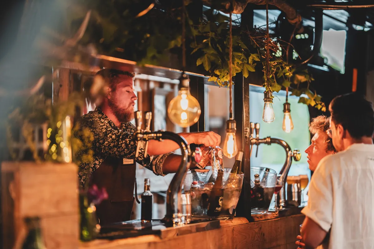 Serveur aux tireuses du bar mobile installé dans l’atelier Timberframing