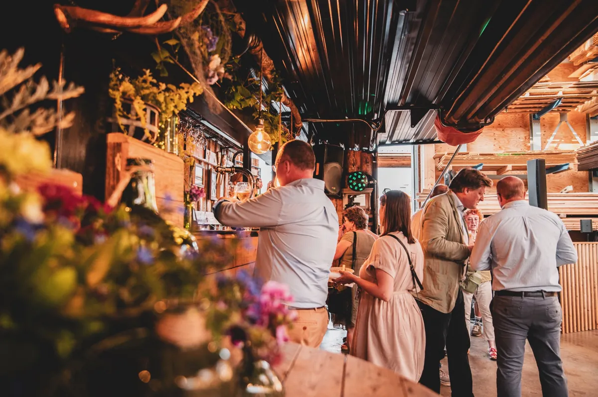 Collègues au comptoir fleuri de La Buvette Champêtre lors d’une fête du personnel